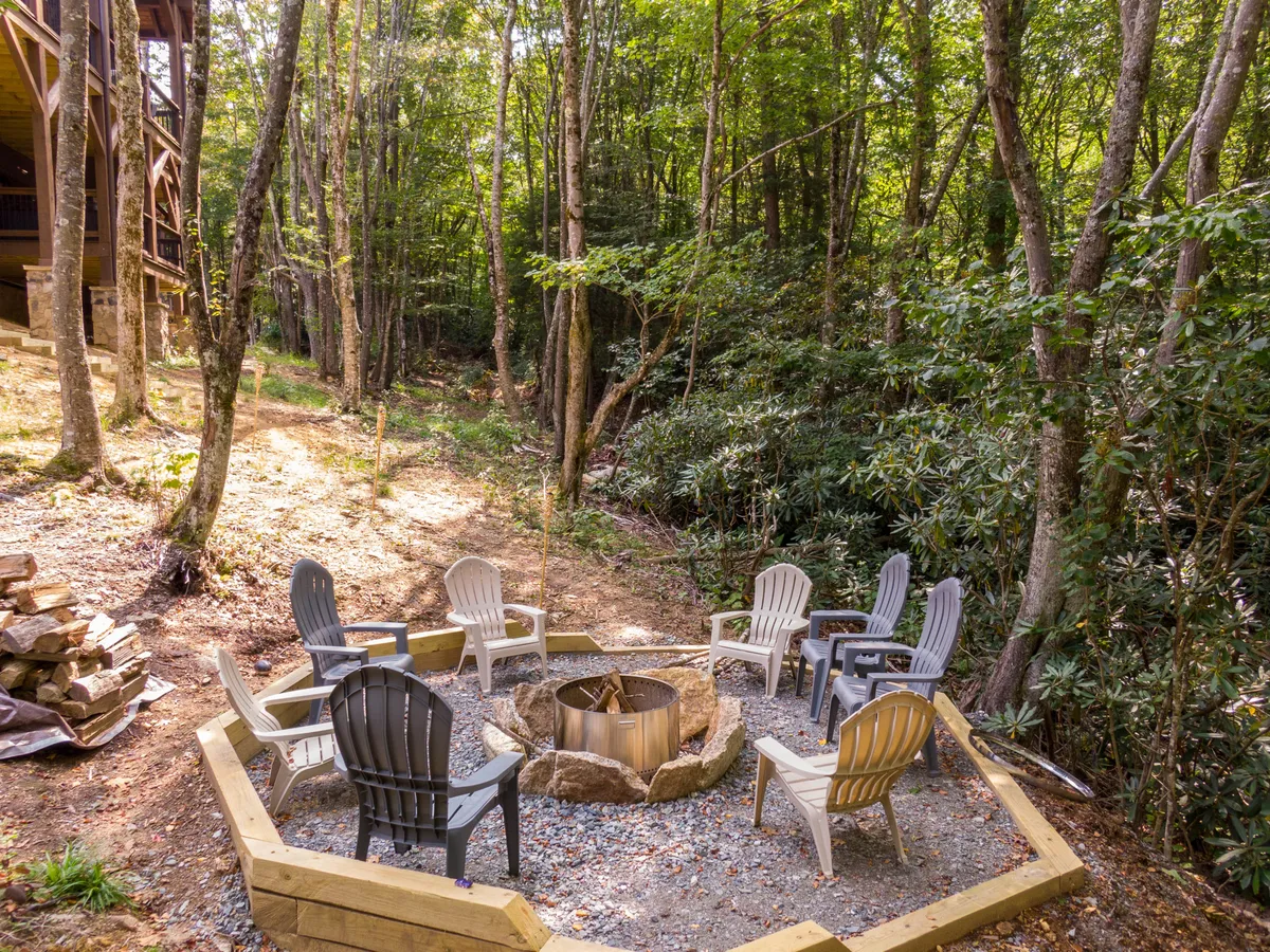 A cozy fire pit encircled by chairs, nestled amid natural foliage. The image suggests communal evenings spent sharing stories, stargazing, or enjoying the crisp mountain air.