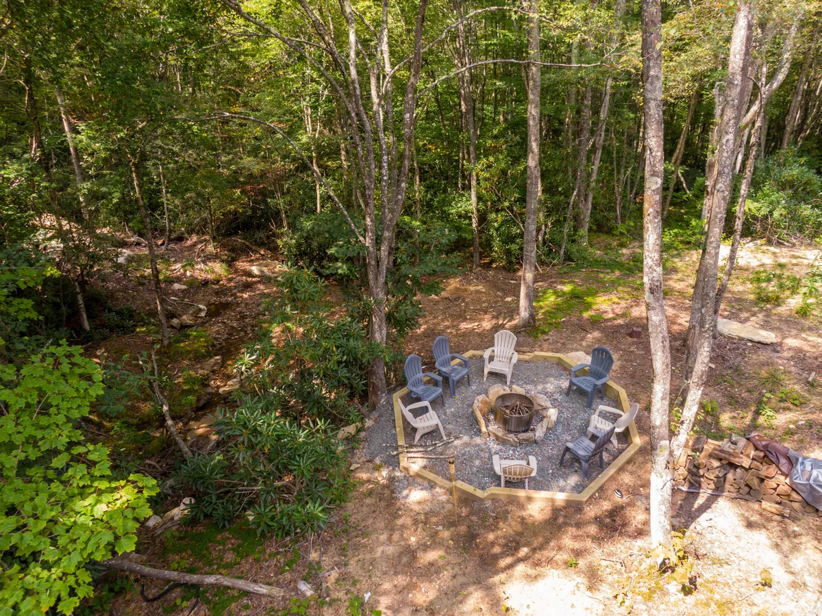 A cozy fire pit surrounded by chairs set amidst lush greenery. The setting invites families and groups to gather for storytelling, marshmallow roasting, and stargazing, embodying the relaxed and communal side of Eagles Nest's outdoor offerings.