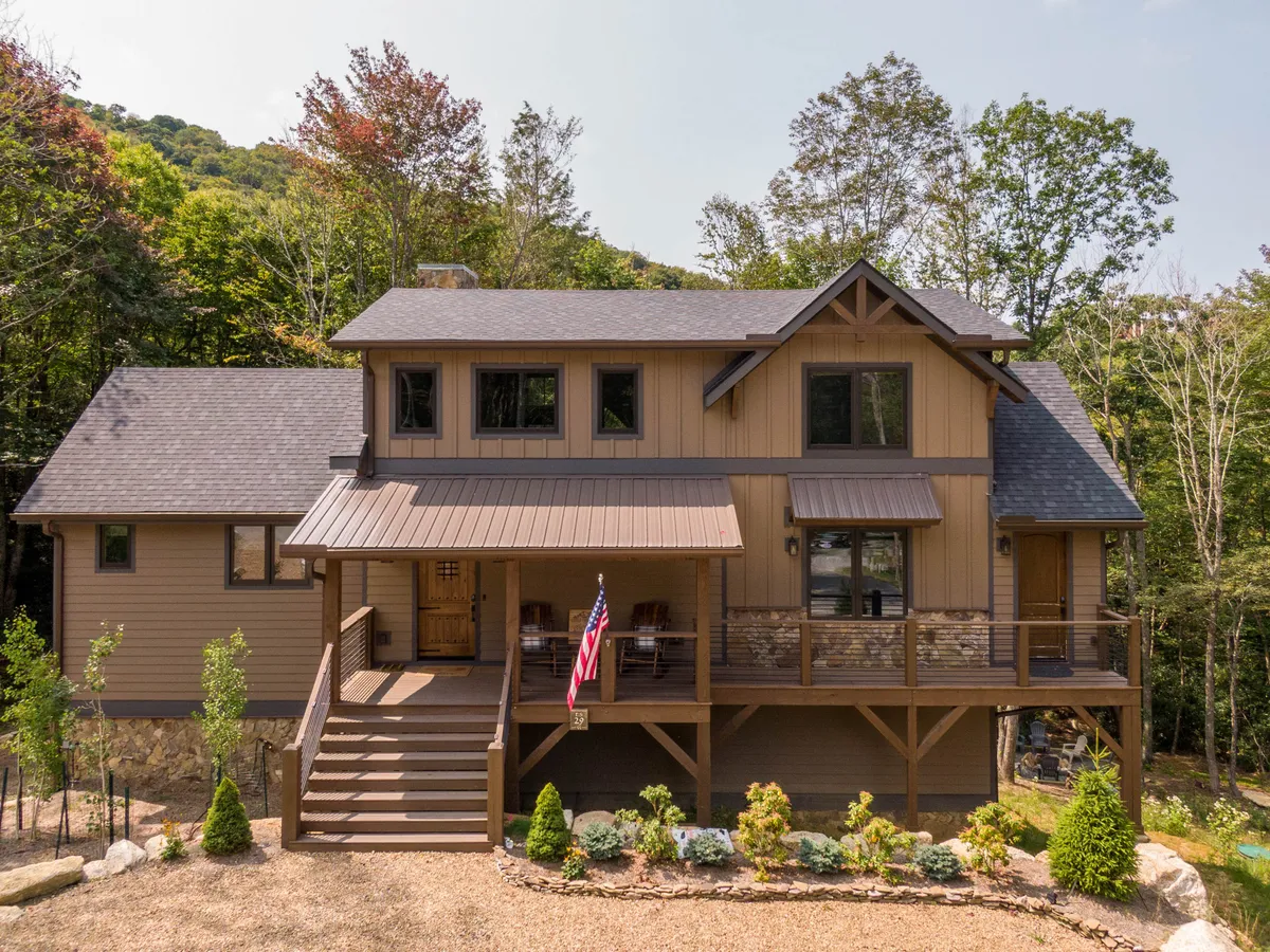An inviting exterior shot of a home with a welcoming front porch, wooden railings, and well-kept landscaping. The porch hints at a relaxing place to unwind after outdoor activities, with easy access to nature right outside the door.